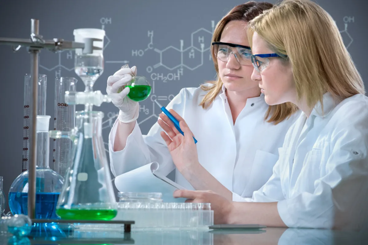 Deux chimistes examinent un flacon au laboratoire