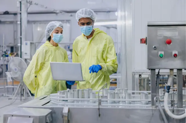 Deux techniciens en tenue près d’une ligne alimentaire