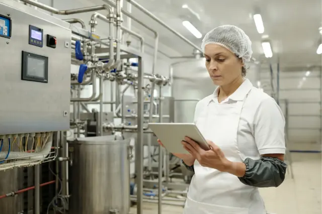 Technicienne qui suit la production sur sa tablette
