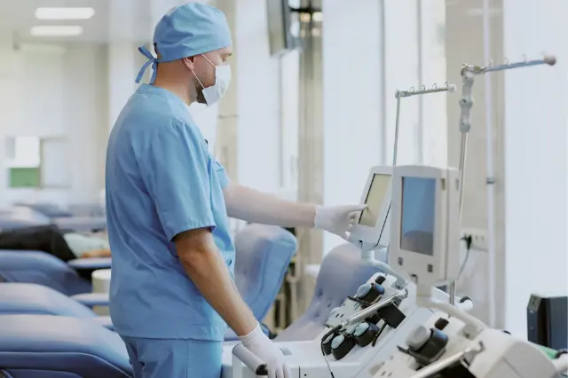 Gowned technician next to medical equipment