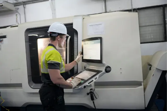 Technicienne au poste de commande d’une machine