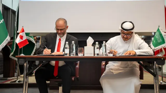 Les deux présidents signent l’accord, drapeaux du Canada et de l’Arabie saoudite sur la table