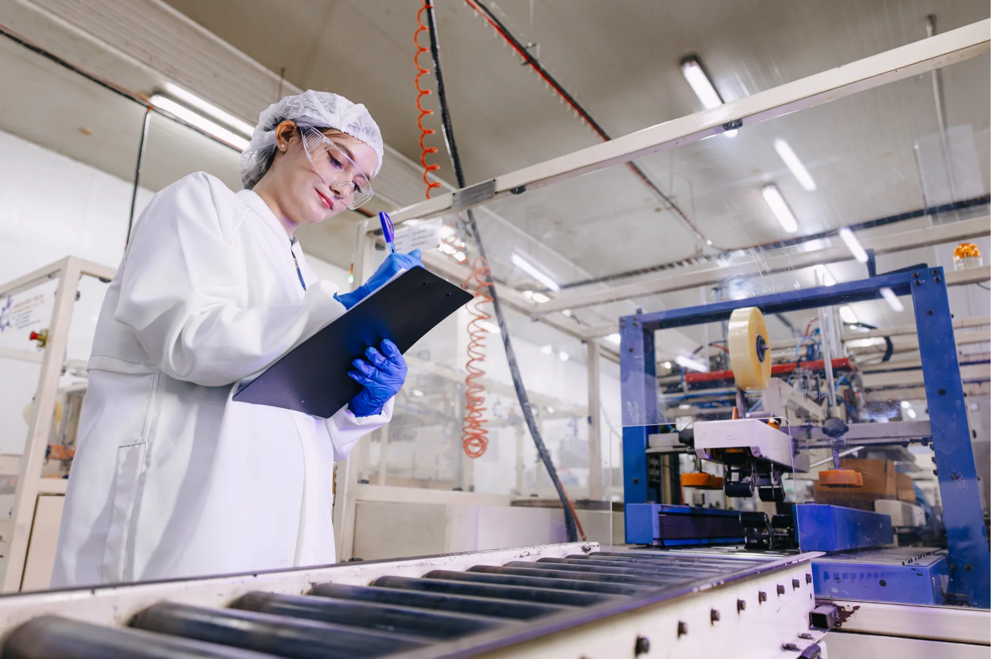 Auditor taking notes in front of a production line